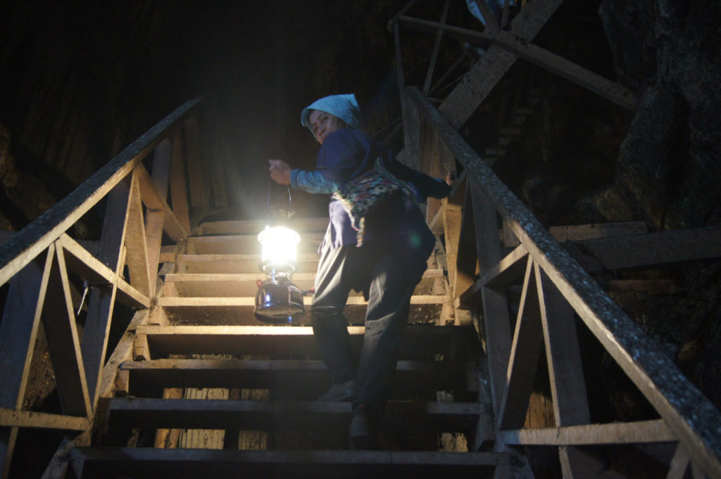 Our Tham Lot Cave tour guide lights the way with her paraffin lamp