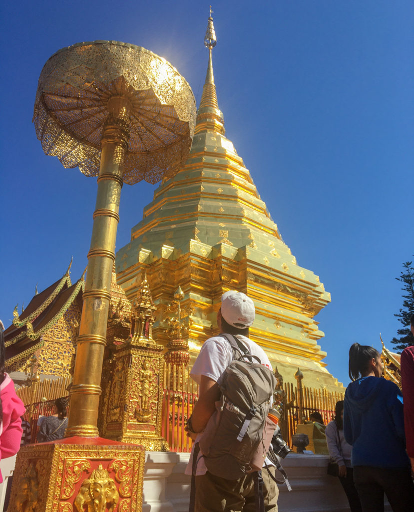 Me, gazing up at the golden dome of Doi Suthep temple, in Chiang Mai, Thailand
