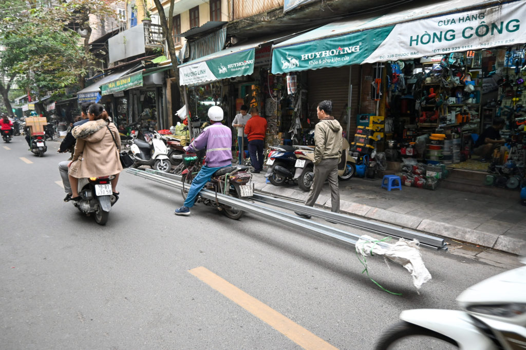 Motorbiker in Hanoi carrying absurdly long steel beams